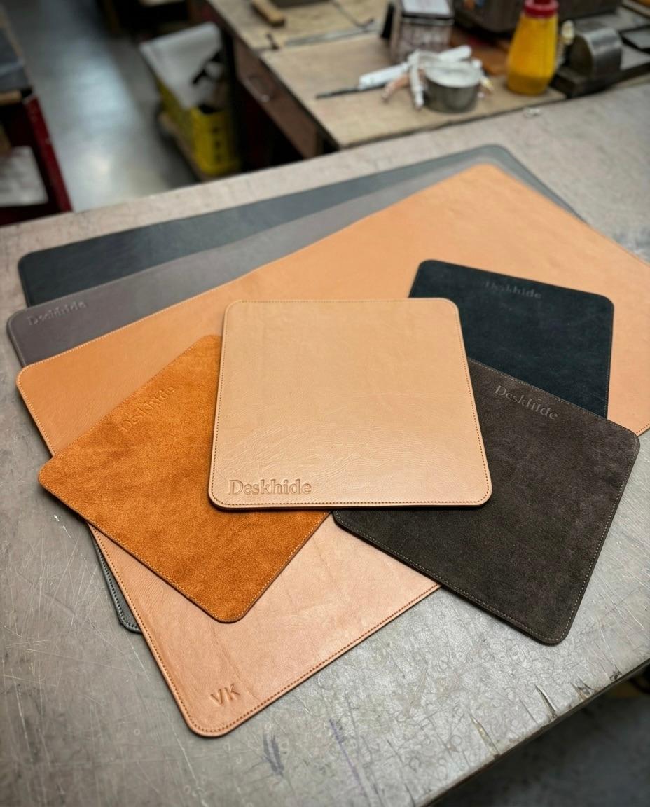Handcrafted leather goods and tools arranged on a rustic wooden workshop table