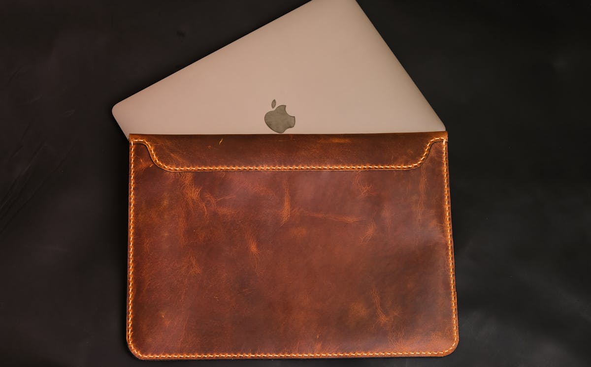 Handcrafted leather sleeve showing rich patina and hand-stitched edges